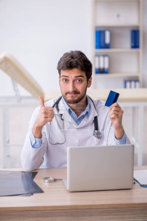 Photo for Young doctor holding credit card - Royalty Free Image