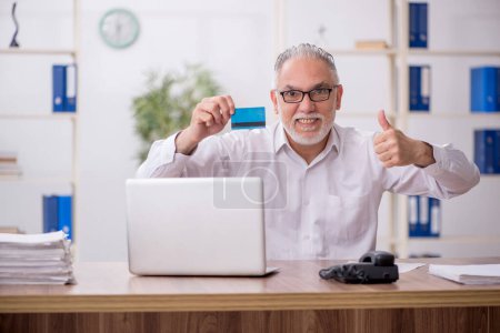 Photo for Old employee holding credit card - Royalty Free Image