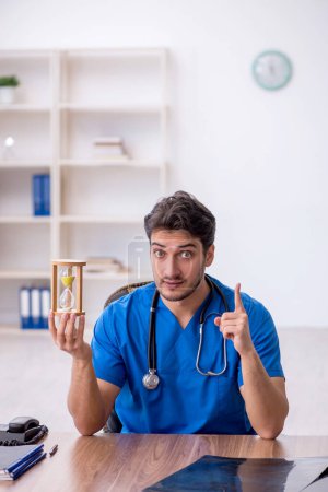 Photo for Young doctor in time management concept - Royalty Free Image