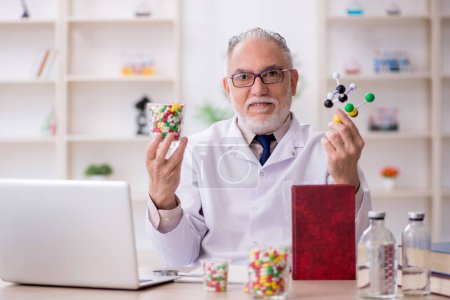 Téléchargez les photos : Vieux médecin tenant modèle moléculaire - en image libre de droit