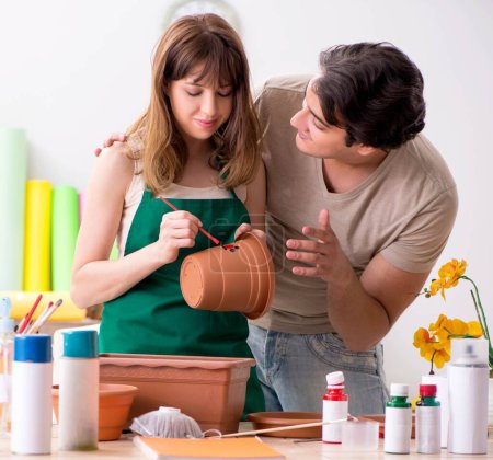 Photo for The couple decorating pots in workshop during class - Royalty Free Image