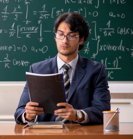 Téléchargez les photos : Le jeune professeur de mathématiques masculin en classe - en image libre de droit