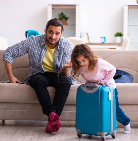 Photo for Man and his small daughter preparing for the trip - Royalty Free Image