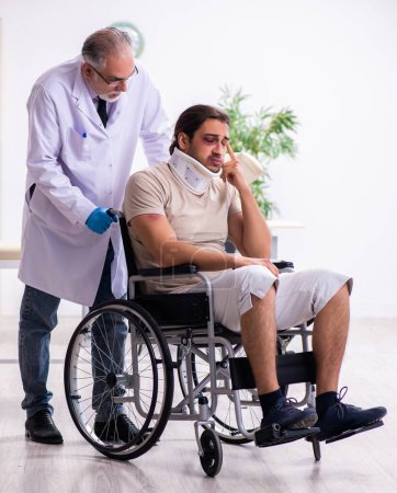 Foto de Joven rostro herido hombre visitando experimentado médico traumatólogo - Imagen libre de derechos