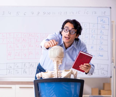 Foto de El joven profesor de química masculina y esqueleto de estudiante - Imagen libre de derechos