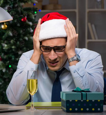 Foto de El hombre de negocios que trabaja hasta tarde en Navidad en la oficina - Imagen libre de derechos