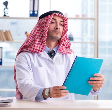 Téléchargez les photos : Le médecin arabe travaillant à la clinique - en image libre de droit