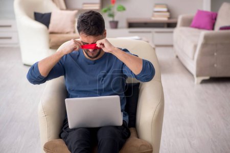 Photo for Blindfolded young freelancer working from home - Royalty Free Image