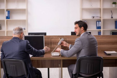 Photo for Two male colleagues sitting at workplace - Royalty Free Image