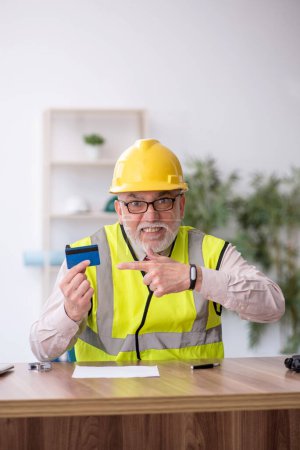 Photo for Old architect holding credit card - Royalty Free Image