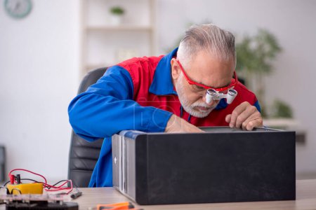 Foto de Viejo reparador reparando computadora en el laboratorio - Imagen libre de derechos