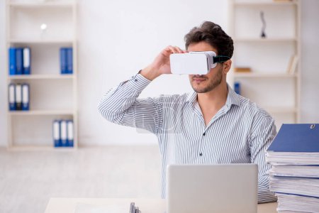 Téléchargez les photos : Jeune employé jouissant de lunettes virtuelles au bureau - en image libre de droit