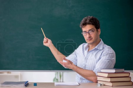Photo for Young teacher in front of green board - Royalty Free Image