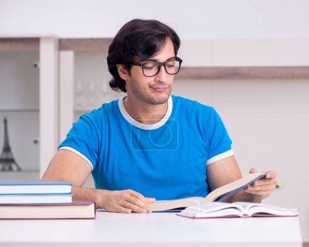 Foto de El joven estudiante guapo que estudia en casa - Imagen libre de derechos