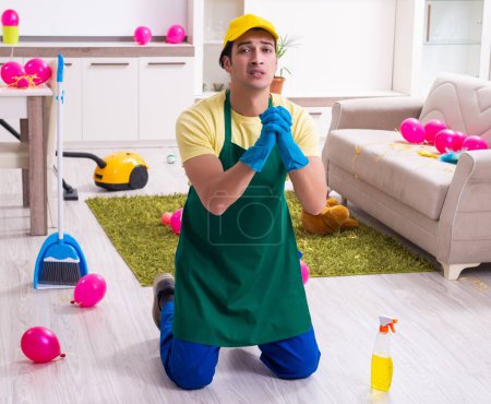 Foto de El joven contratista haciendo tareas domésticas después de la fiesta - Imagen libre de derechos
