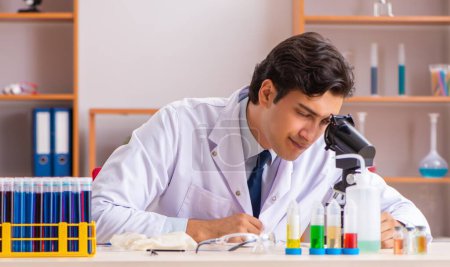 Téléchargez les photos : Le jeune et beau biochimiste qui travaille au labo - en image libre de droit