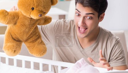 Téléchargez les photos : Le jeune père profiter du temps avec le nouveau-né à la maison - en image libre de droit