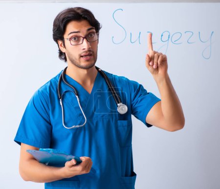 Téléchargez les photos : The young male doctor in front of whiteboard - en image libre de droit