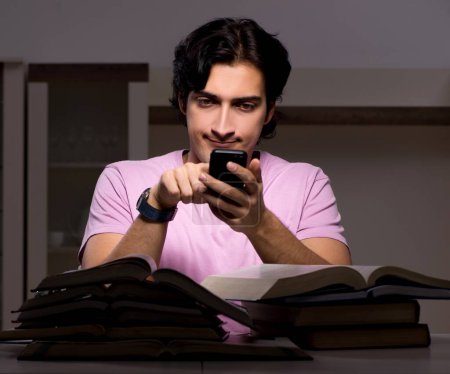 Photo for The male handsome student preparing for exams late at home - Royalty Free Image