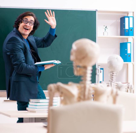 Téléchargez les photos : Le professeur masculin et étudiant squelette dans la salle de classe - en image libre de droit