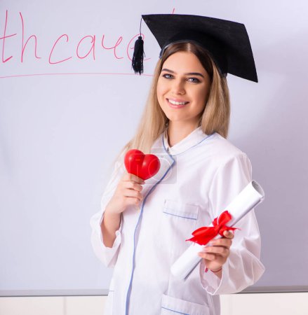 Photo for The young female doctor standing in front of the white board - Royalty Free Image