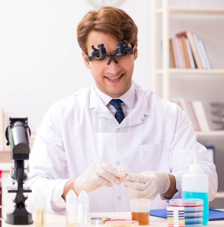 Téléchargez les photos : Le chimiste au labo vérifie avec des bandelettes ph - en image libre de droit