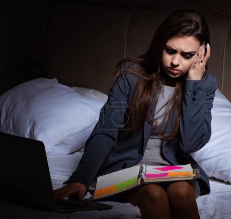 Téléchargez les photos : La femme d'affaires fatiguée faisant des heures supplémentaires à la maison la nuit - en image libre de droit