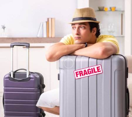 Téléchargez les photos : L'homme qui part en vacances avec des valises fragiles - en image libre de droit