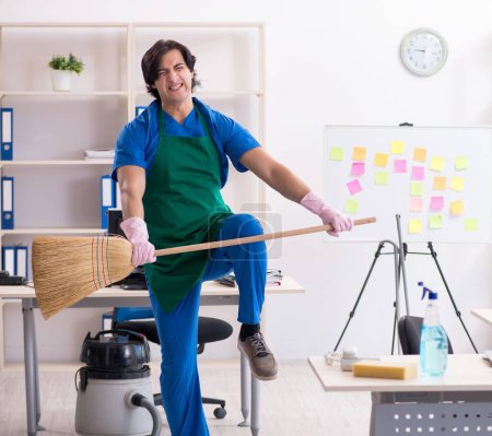 Photo for The male handsome professional cleaner working in the office - Royalty Free Image