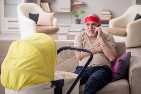 Photo for Aged man looking after newborn at home - Royalty Free Image