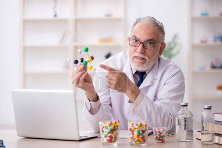 Foto de Viejo doctor sosteniendo modelo molecular - Imagen libre de derechos
