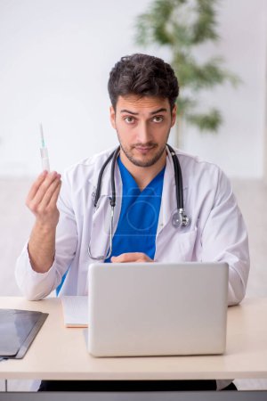 Photo for Young doctor holding syringe at the hospital - Royalty Free Image
