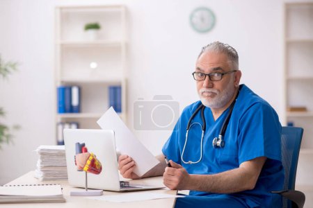 Photo for Old doctor working in the clinic - Royalty Free Image