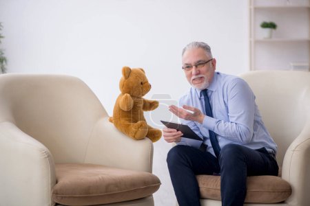 Téléchargez les photos : Vieux psychologue et ours doux dans la chambre - en image libre de droit