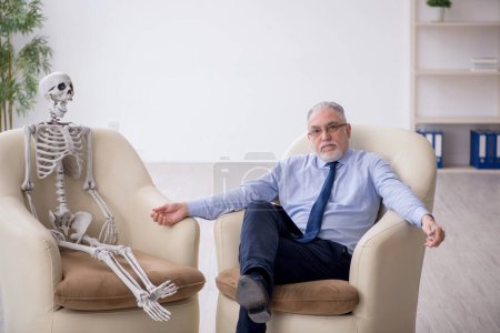 Téléchargez les photos : Vieux psychologue rencontre avec squelette - en image libre de droit
