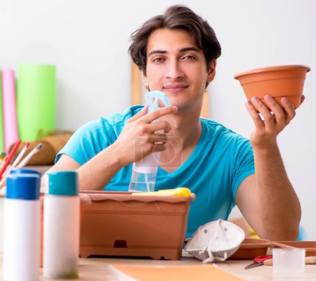 Photo for The young man decorating pottery in class - Royalty Free Image