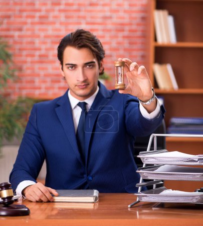 Foto de El joven guapo abogado que trabaja en su oficina - Imagen libre de derechos