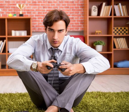 Téléchargez les photos : Le jeune employé jouant à des jeux de joystick pendant sa pause - en image libre de droit