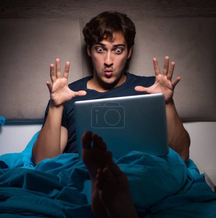 Photo for The man working on laptop at night in bed - Royalty Free Image