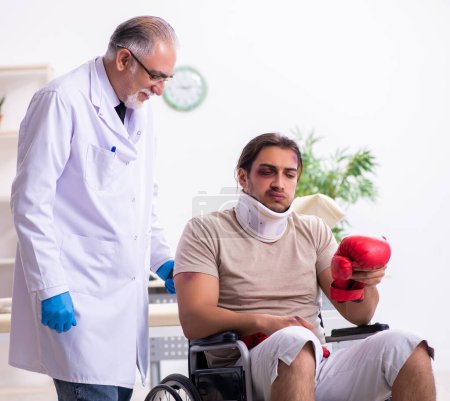 Téléchargez les photos : Jeune visage blessé homme visitant expérimenté médecin traumatologue - en image libre de droit