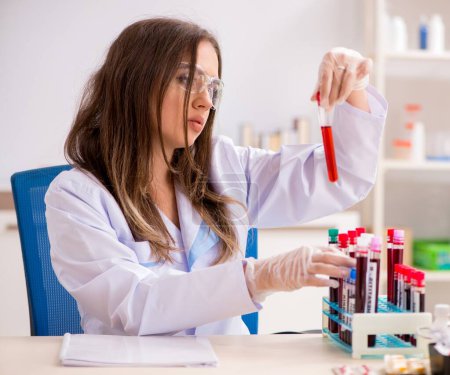 Téléchargez les photos : La jeune belle assistante de laboratoire testant des échantillons de sang - en image libre de droit
