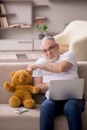 Foto de Viejo con oso de juguete en la casa - Imagen libre de derechos