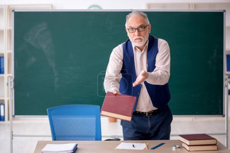 Téléchargez les photos : Vieil enseignant devant le panneau vert - en image libre de droit