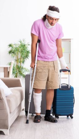 Photo for The young injured man preparing for the trip - Royalty Free Image