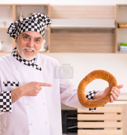 Photo for The old male baker working in the kitchen - Royalty Free Image