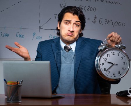 Foto de El especialista financiero que trabaja hasta tarde en la oficina - Imagen libre de derechos
