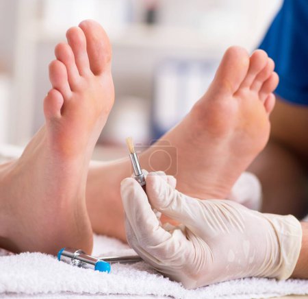 Foto de El podólogo que trata los pies durante el procedimiento - Imagen libre de derechos