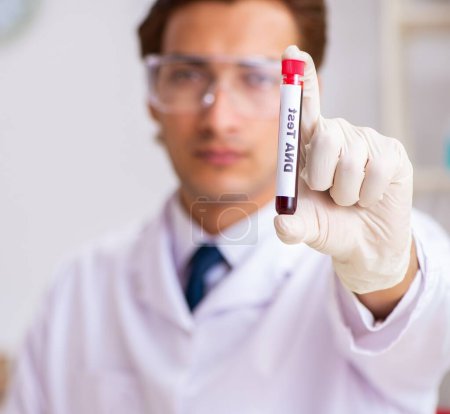 Photo for The young handsome lab assistant testing blood samples in hospital - Royalty Free Image