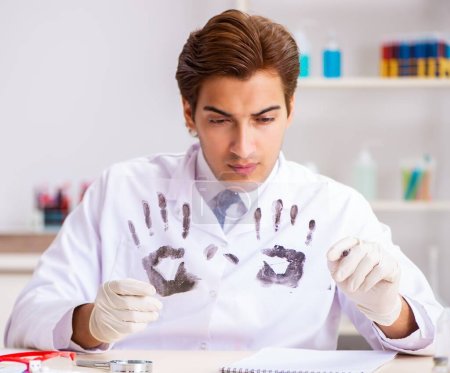 Foto de El experto forense estudiando huellas dactilares en el laboratorio - Imagen libre de derechos