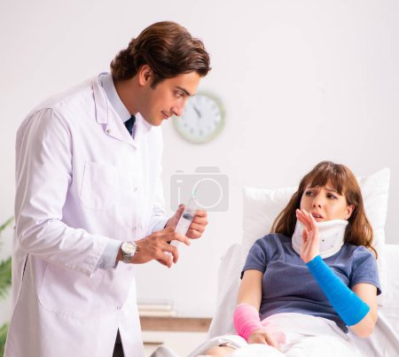 Photo for The young doctor examining injured patient - Royalty Free Image